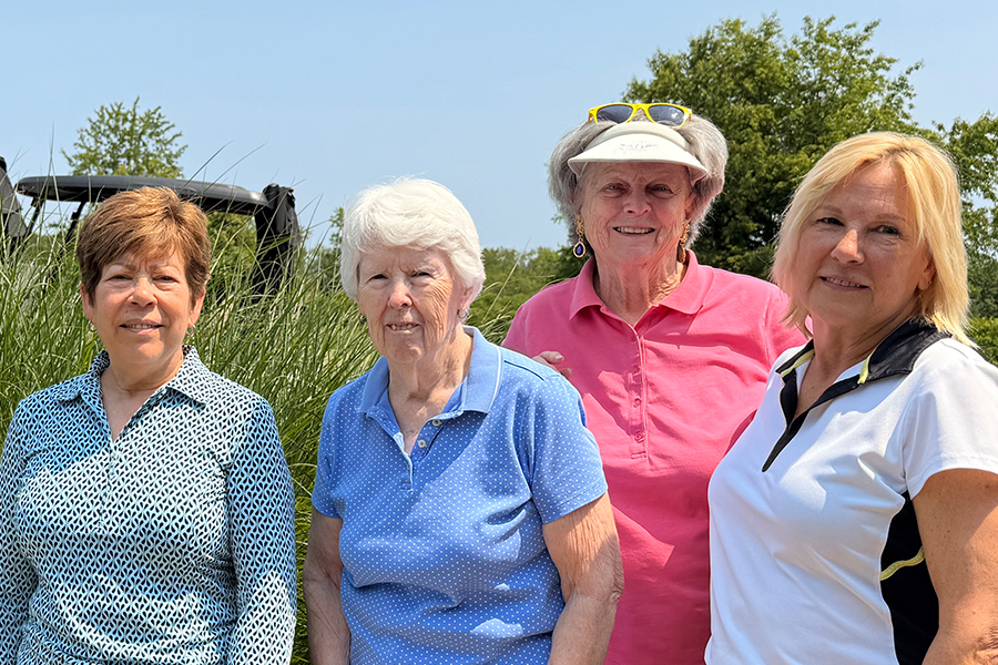 four older women on a golf course
