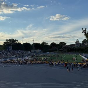 football field with people on it and a cloudy sky