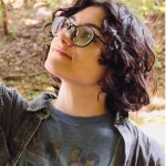 teen with curly hair and glasses