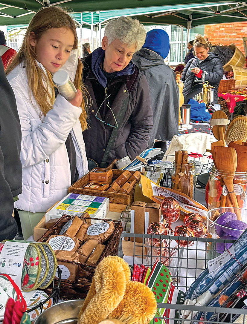 girl and older woman looking at shopping table outdoors