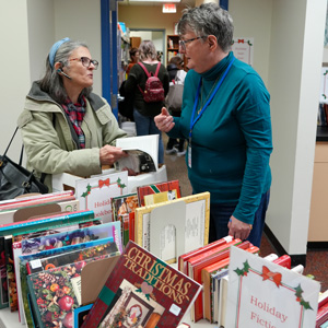 two adults talking near books