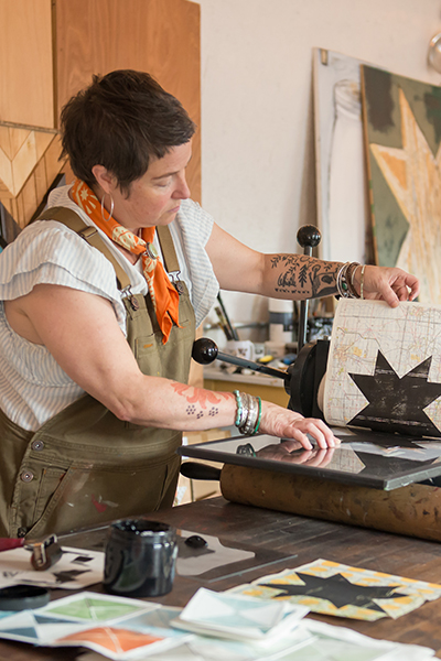 woman with short hair holding artwork
