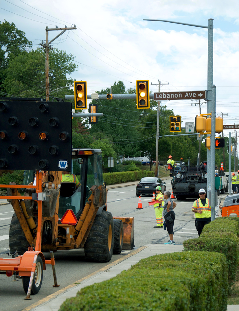 construction vehicles blocking a road next to a traffic light 