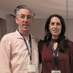 man and woman smiling with lanyards and dress shirts
