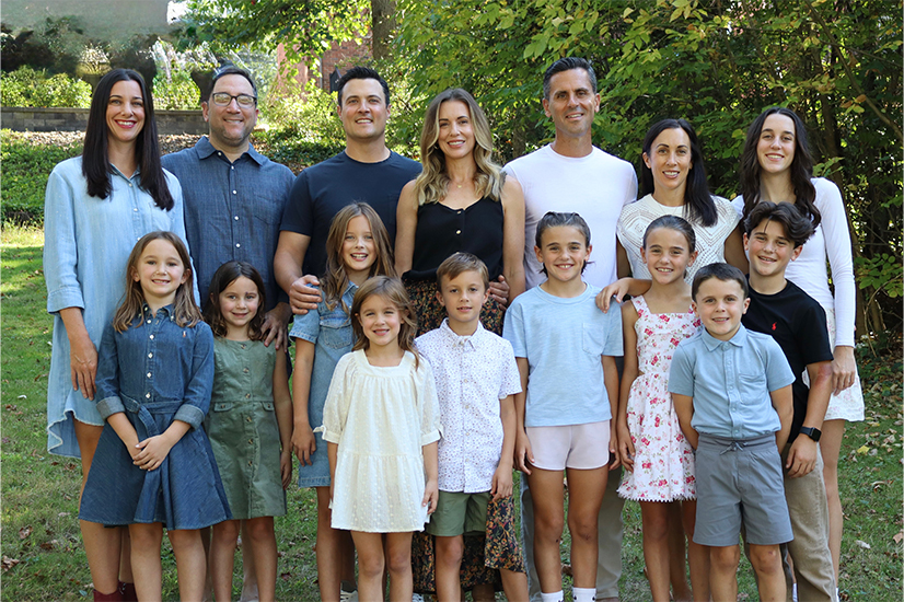 family photo with 6 adults and 10 kids outside