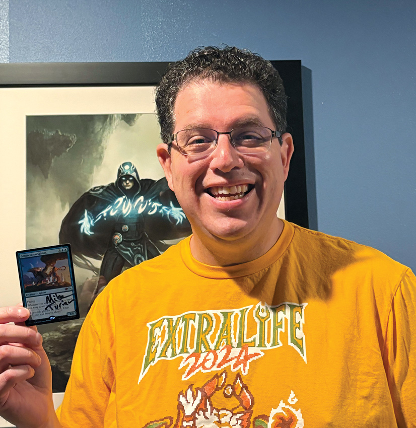 man smiling holding a card