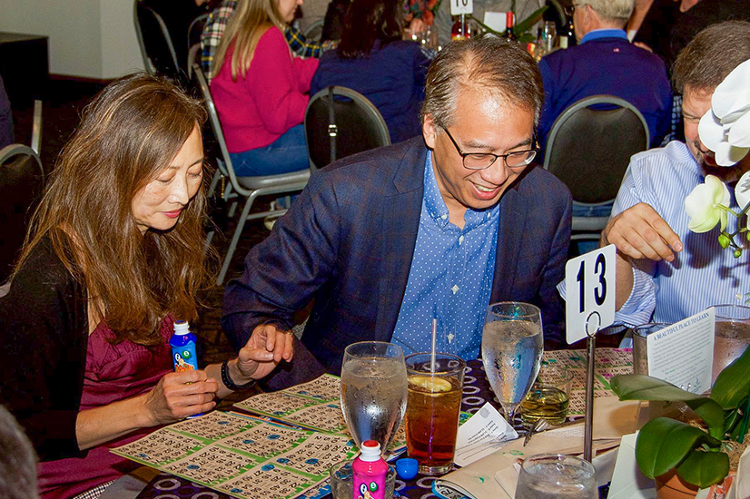 man and woman sitting at table playing bingo