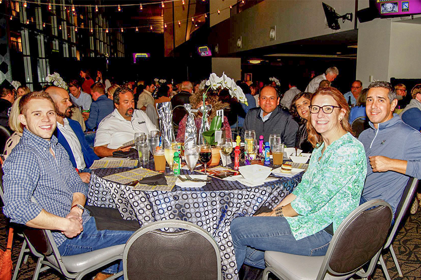 group photo of adults smiling sitting around a table at a bingo event