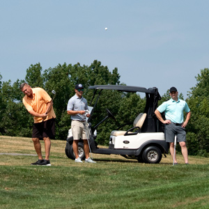 three men golfing in shorts and polos
