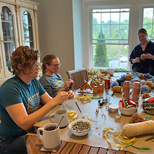adults making crafts at dining room table