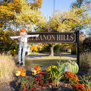 the entrance to mission hills neighborhood, its decorated with pumpkins and a scarecrow
