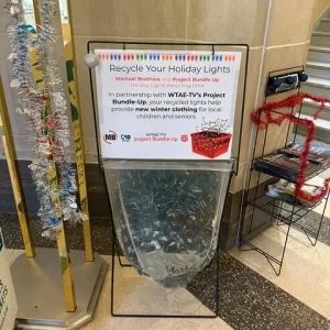 sign for christmas light recycling and bag filled with string lights