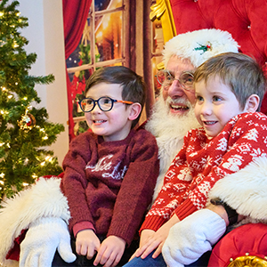 two boys sitting on santa's lap