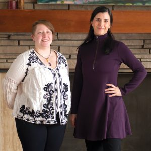 two adults smiling standing indoors
