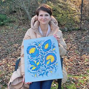 a woman sitting in a chair holding artwork