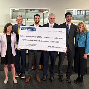 group photo of adults at a recreation center holding a large check