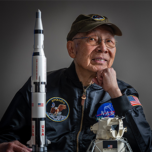 older man smiling with nasa jacket and model rocket