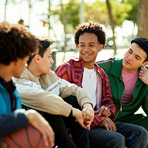 four teenage boys talking outside