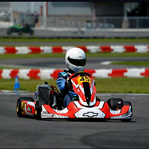 A teen in a red kart on a race track