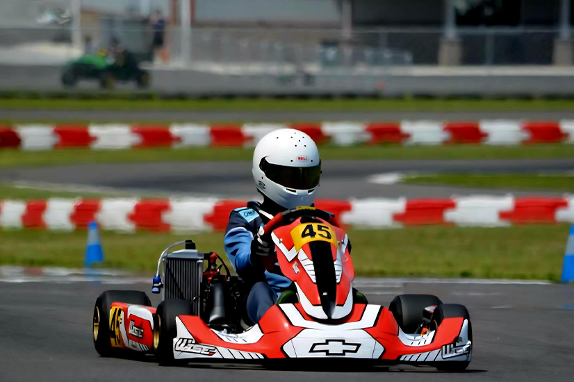 A teen in a red kart on a race track